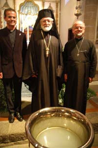 Sacerdotes ortodoxos oficiantes, ante la pila bautismal